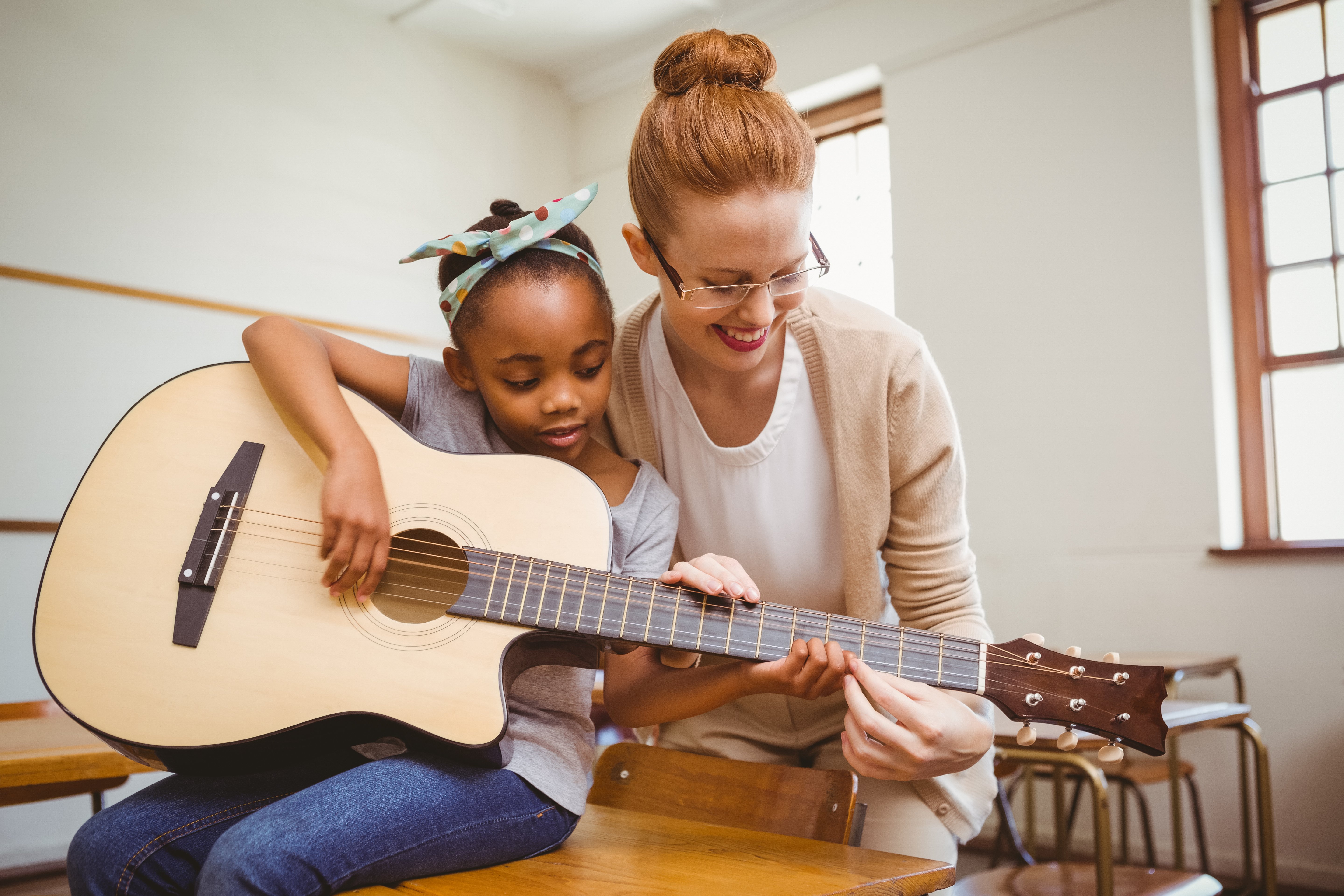 Les avantages d'apprendre la guitare à un enfant • Spectacles pour enfants